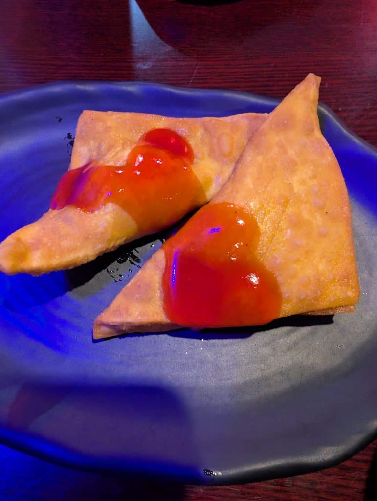 Crispy golden-brown cream cheese wontons served on a plate at Kira Sushi in Lake Ronkonkoma, NY.