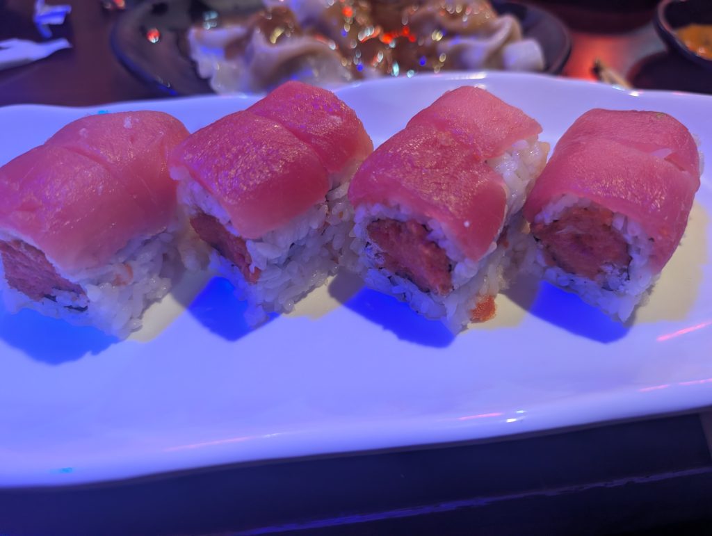 Red dragon roll topped with tuna on a white plate