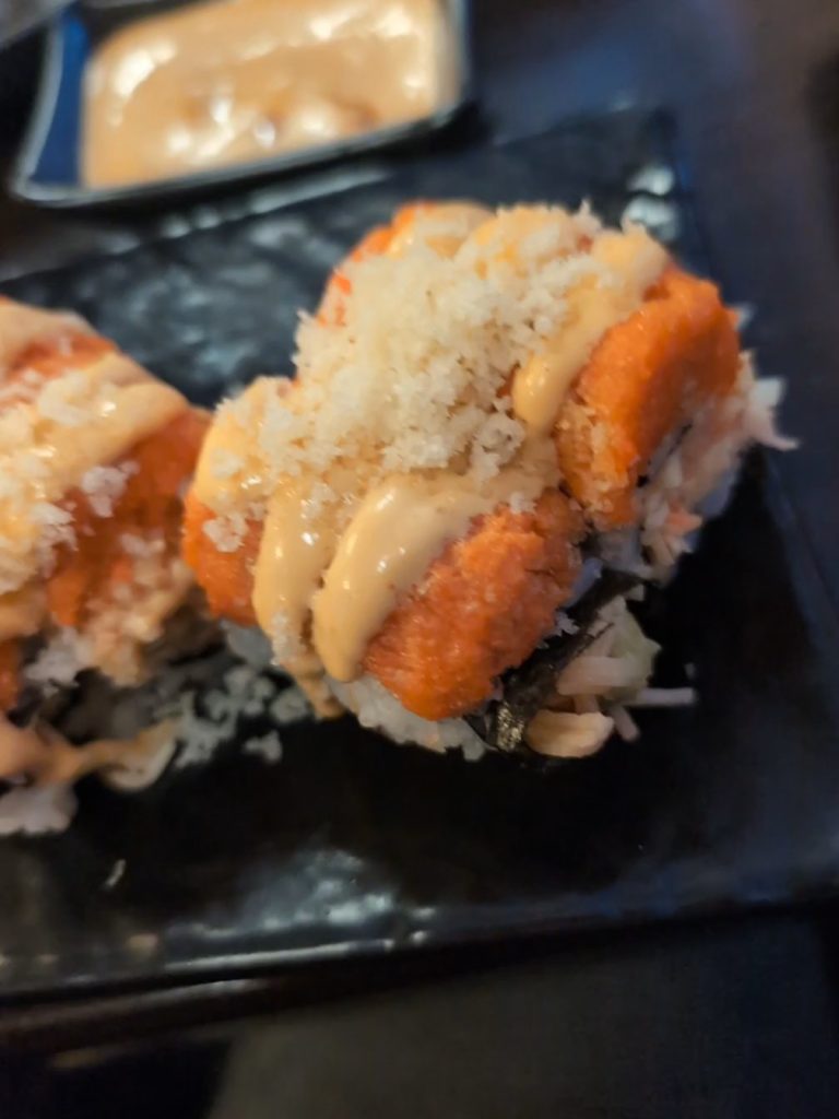 shushi roll with brown crunchies on top.