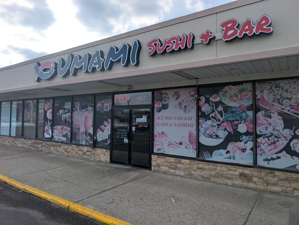 Umami storefront. With black and red sign.